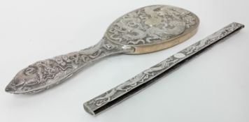 A Chinese silver oval Brush Back and Comb Back with coiled dragons in relief by Tuck Chang of