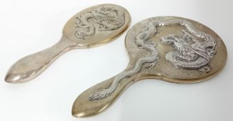 A Chinese silver circular Hand Mirror and Brush Back with curled three toed dragons in high relief