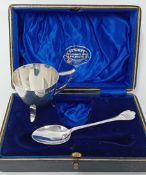 A silver egg cup on feet and a spoon, hallmarked Sheffield 1915, cased, together with a silver