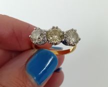 An 18ct yellow gold round brilliant cut three stone diamond ring