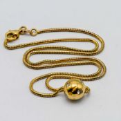 An 18ct yellow gold diamond set ball pendant on chain, assessed total diamond weight approx 0.
