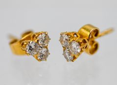 A pair of 18ct yellow gold triple diamond set stud earrings (not hallmarked), approx 2.17g.