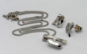 An 18ct white gold necklace and pendant, set with a single diamond and a pair of matching
