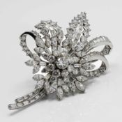 A stunning large floral design diamond brooch with twisted bow design, set a centred cluster and a