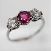 A ruby and diamond three stone ring, set in white (gold?), size L (not hallmarked).