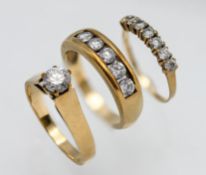 Three 9ct dress rings including a single stone ring, a 9ct seven stone CZ ring and a 9ct 5 stone