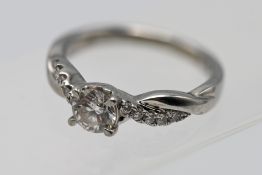 A modern platinum and diamond solitaire ring set with diamonds to the shoulders,