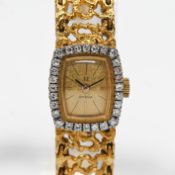 A ladies 18ct Omega bracelet watch, the dial set within a border of diamonds on a fine and ornate