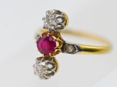 A ruby and diamond three stone ring, set with further diamonds to the shoulders, set in yellow gold,