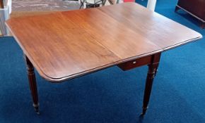 An early 19th century mahogany dining table, circa 1830, with folding flaps, on fluted Gillows-style