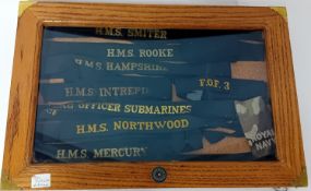 A collection of nine ship's tallies, in a display case.