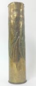 Trench art, a brass shell case with foliate decoration.