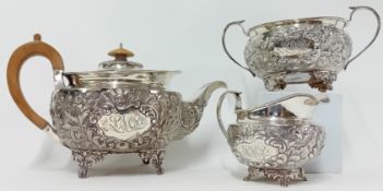 A George III silver tea service, to include teapot with wooden handle, sugar bowl, and milk jug,