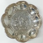 A Victorian silver decorated dish, embossed knightly cavalry combat scene, hallmarked Chester