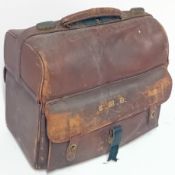 A Victorian leather travel bag fitted with silver mounted glass bottles, mirror, etc, together