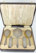 A silver dressing table set, cased, to include two hairbrushes, two clothes brushes, comb (missing