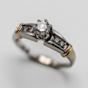 A diamond solitaire ring set with further diamonds to the shoulders, set in 14k white gold, approx