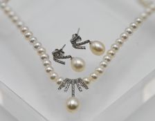 A diamond and pearl jewellery set to include earrings and necklace, set in 9ct white gold. Purchased
