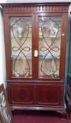 Early 20th century mahogany two door display cabinet fitted with a lower cupboard, on bracket