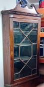 A Georgian mahogany wall hanging corner cabinet with open swan neck pediment, single door with