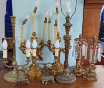 Various gilt and brass lamps and candlesticks, of classical design and cupid motifs.