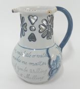 An 18th century tin-glazed earthenware puzzle jug, blue and white painted motto to front, height
