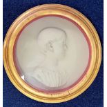A Victorian white stone relief portrait of a young girl in profile, in a round gilt frame, glazed,