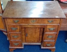 A 18th century walnut kneehole desk fitted with an arrangement of 8 drawers and a kneehole