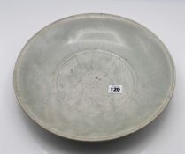 A celadon charger, 19th/20th century or later, freely carved in the centre with a fish amongst lotus