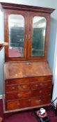 A 18th century walnut bureau bookcase. The upper section with a moulded cornice over a pair of doors