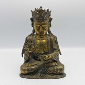 A parcel gilt-bronze figure of Guanyin, 19th century, cast seated cross-legged with the robes open