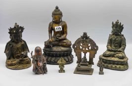 Three seated bronze deities comprising; two seated Guanyin, 19cm and 20cm and a figure of a seated