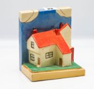A single Clarice Cliff cottage with orange roof bookend.