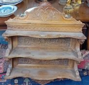 A set of light carved oak wall hanging bookshelves. Width 83cm.