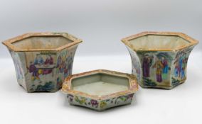 A pair of hexagonal Canton ‘famille-rose’ jardinieres and one stand, 19th century, each of flared
