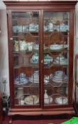 An early 20th century mahogany two door display cabinet with Grecian key-cut moulded cornice, two