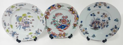 Three 18th century English Delftware plates of polychrome floral design. (3)