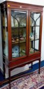 An Edwardian mahogany inlaid two door display cabinet, on square tapered legs with spayed feet.