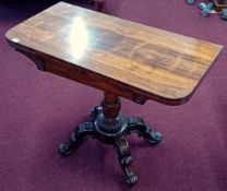 A 19th Century rosewood fold over tea table with turned and twist central column raised on four