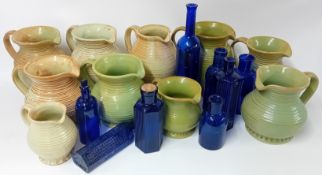 Pine wall rack, a collection of green pottery jugs, blue glass medicine bottles (collection).