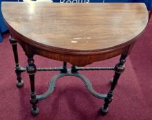 A Victorian mahogany D-shaped fold over gaming table with folding legs.