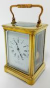 A brass-cased carriage clock, the dial with roman numerals and outer track arabic numerals. Marked