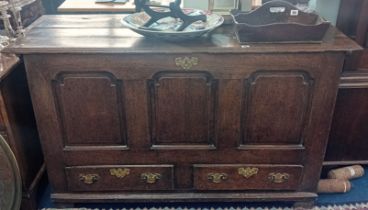 An 18th century oak mule chest with three moulded panels over two drawers fitted with brass plate