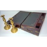 A 19th century campaign writing slope (hinge broken), together with a pair of brass candlesticks.