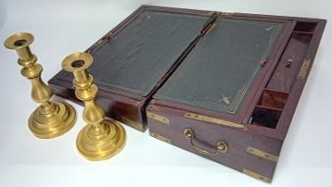 A 19th century campaign writing slope (hinge broken), together with a pair of brass candlesticks.