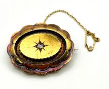 An Edwardian period gold and diamond set memorial brooch, of oval scalloped form