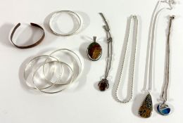 A collection of silver jewellery including three connected bangles, pendants and chains etc.