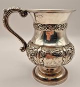 A Victorian silver mug, with embossed floral decoration and inscribed, hallmark rubbed, height 12cm,