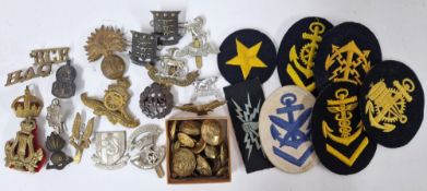 A collection of WWII cap badges, buttons, and patches, to include Royal Warwickshire badge,