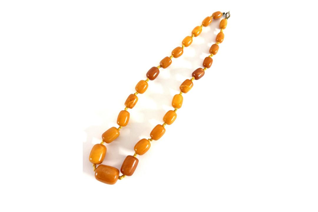 An amber bead necklace, set with twenty four beads, length 50cm, approx 39.3g.
